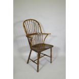 A C19th elm Windsor stick back arm chair, with historic restorations