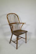 A C19th elm Windsor stick back arm chair, with historic restorations