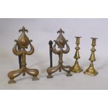 A pair of C19th Art Nouveau fire dogs, 32cm high and a pair of brass candlesticks