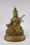 A Tibetan gilt bronzed metal figure of Buddha seated on a lotus throne, impressed double vajra