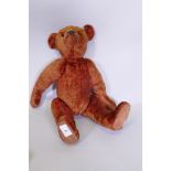 An antique red plush hump back teddy bear, 46cm long