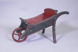 A vintage painted pine child's wheel barrow, 72cm long, 36cm high