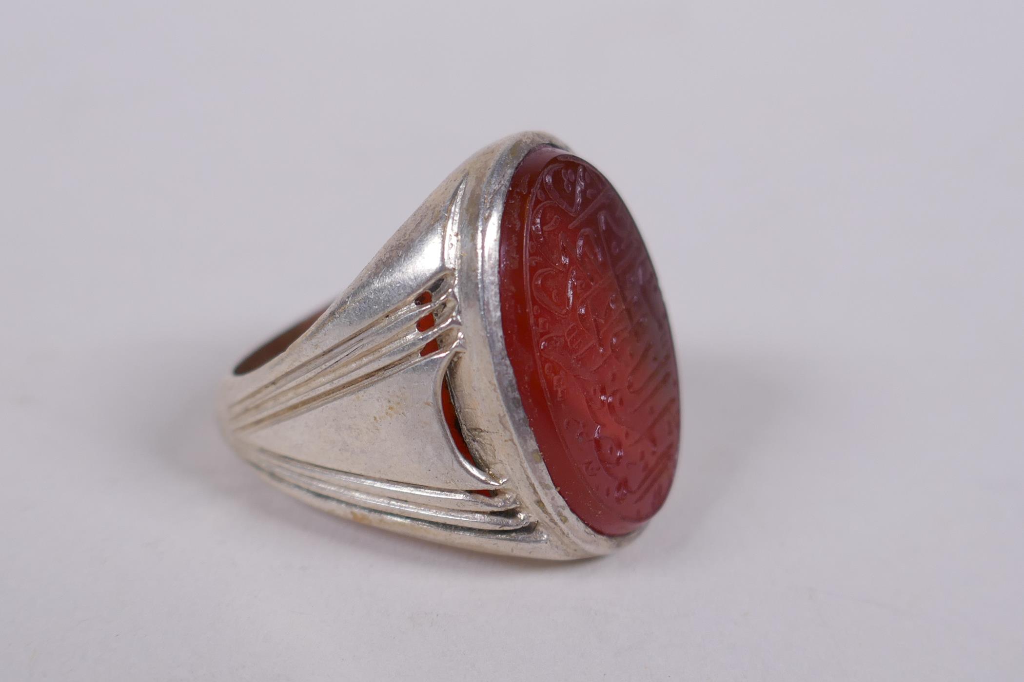 An Islamic white metal ring set with an agate intaglio seal, carved with Islamic script, marks to - Image 2 of 4