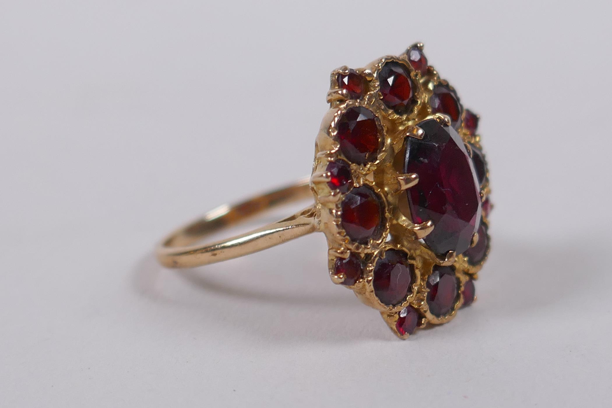 A 9ct yellow gold and garnet dress ring, size N/O