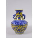 A yellow ground porcelain two handled vase with blue and white lotus flower decoration, Chinese