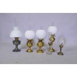 A pair of brass oil lamps with twin duplex wicks, another larger, an Aladdin oil lamp, glass oil