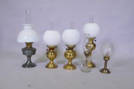 A pair of brass oil lamps with twin duplex wicks, another larger, an Aladdin oil lamp, glass oil