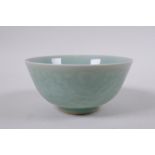 A Chinese celadon glazed porcelain rice bowl, with underglaze carp and lotus flower decoration,