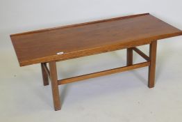 A mid century coffee table, with gallery top, raised on square supports united by stretchers, 114