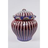 A Chinese flambe glazed porcelain ribbed ginger jar and cover, the cover with a frilled rim and loop