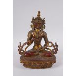 A Sino Tibetan gilt and coppered bronze figure of Buddha, seated and holding a vajra and stupa, 21cm