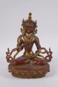 A Sino Tibetan gilt and coppered bronze figure of Buddha, seated and holding a vajra and stupa, 21cm