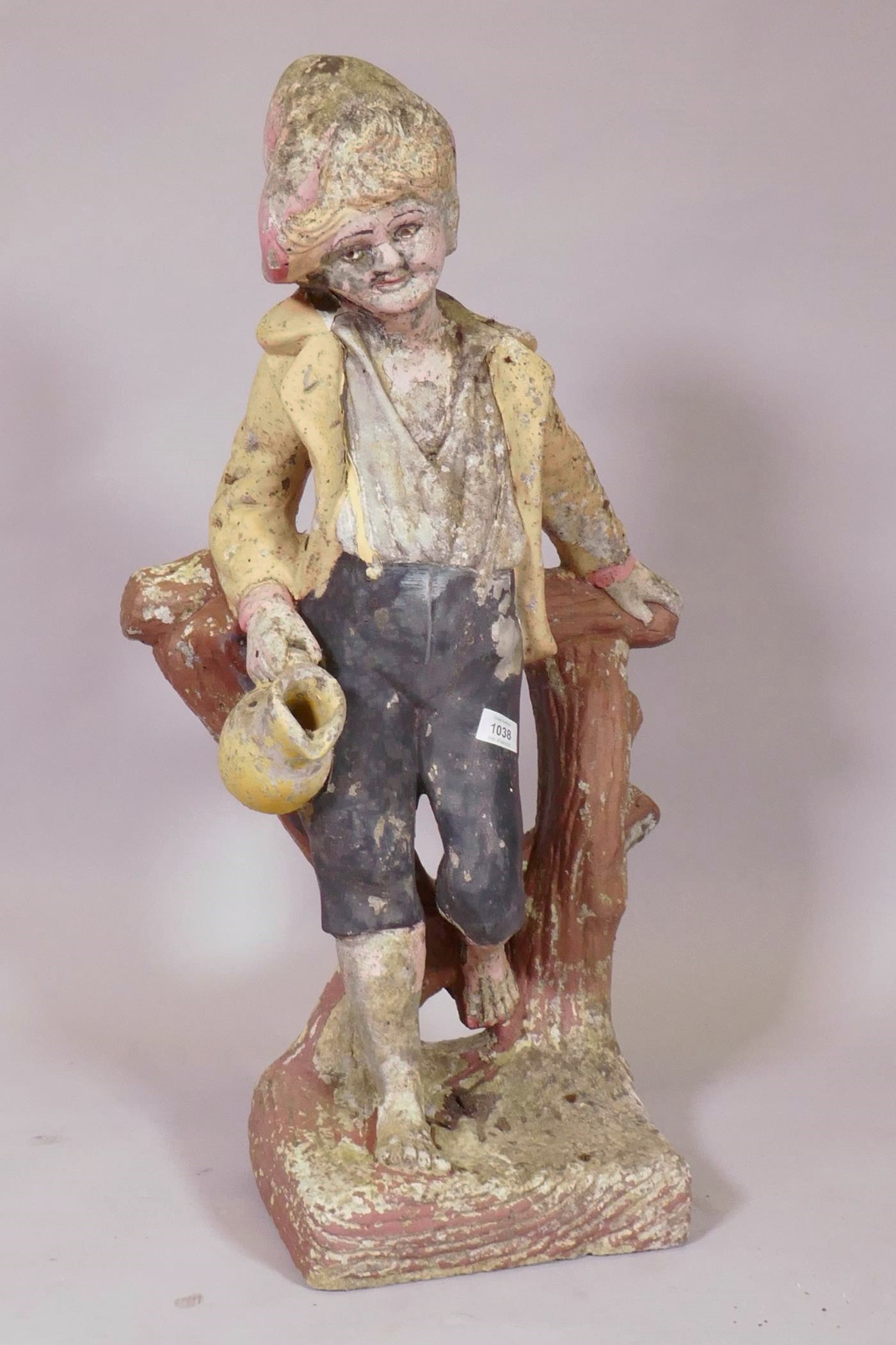 A painted concrete garden figure of a young boy leaning on a tree stump, 80cm high