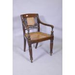 A C19th Anglo Indian style/Zanzibar hardwood elbow chair, with caned seat and back, reeded arms,