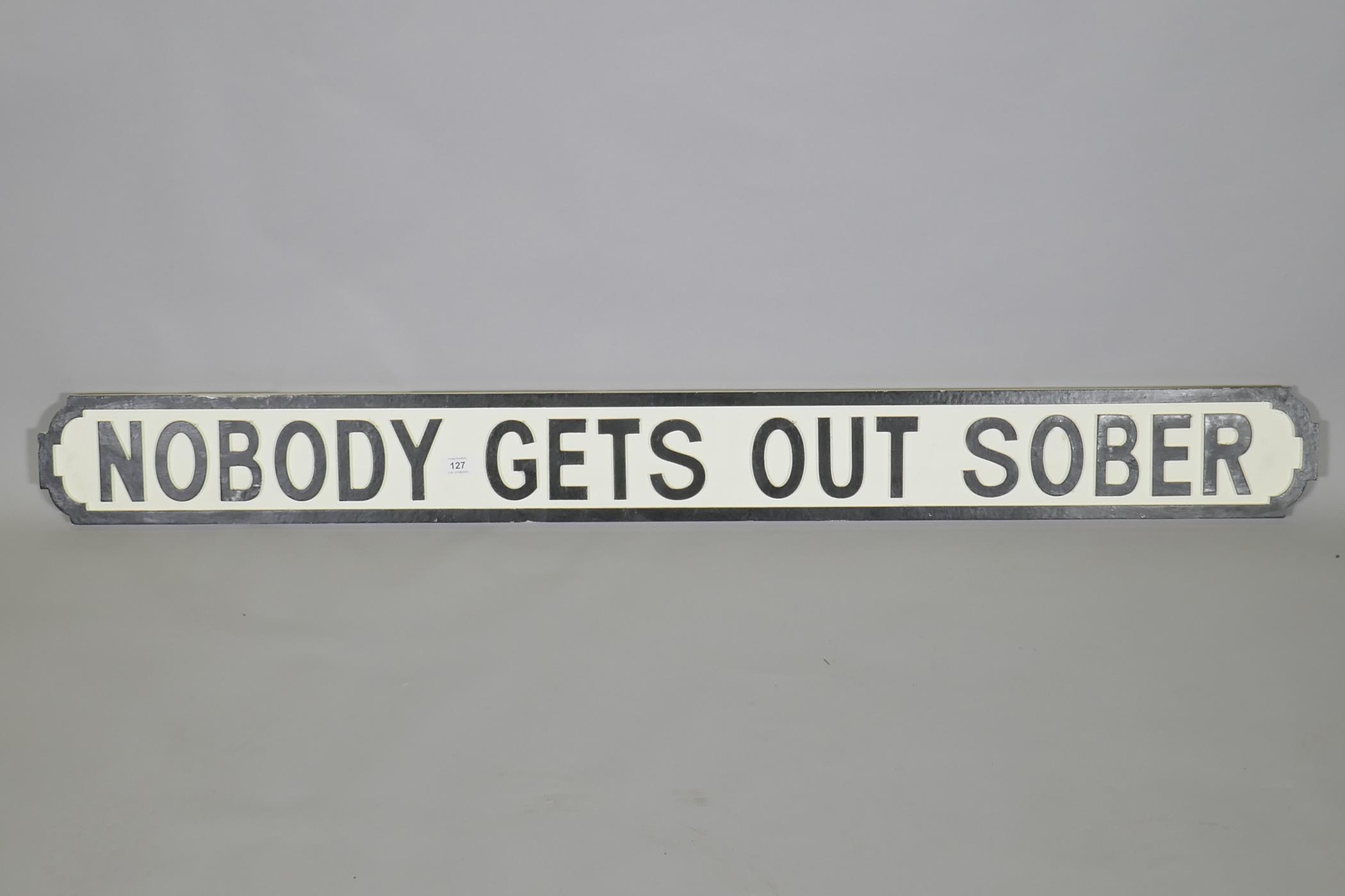 A painted wood sign, 'Nobody Gets Out Sober', in the style of a road sign, 134 x 14cm