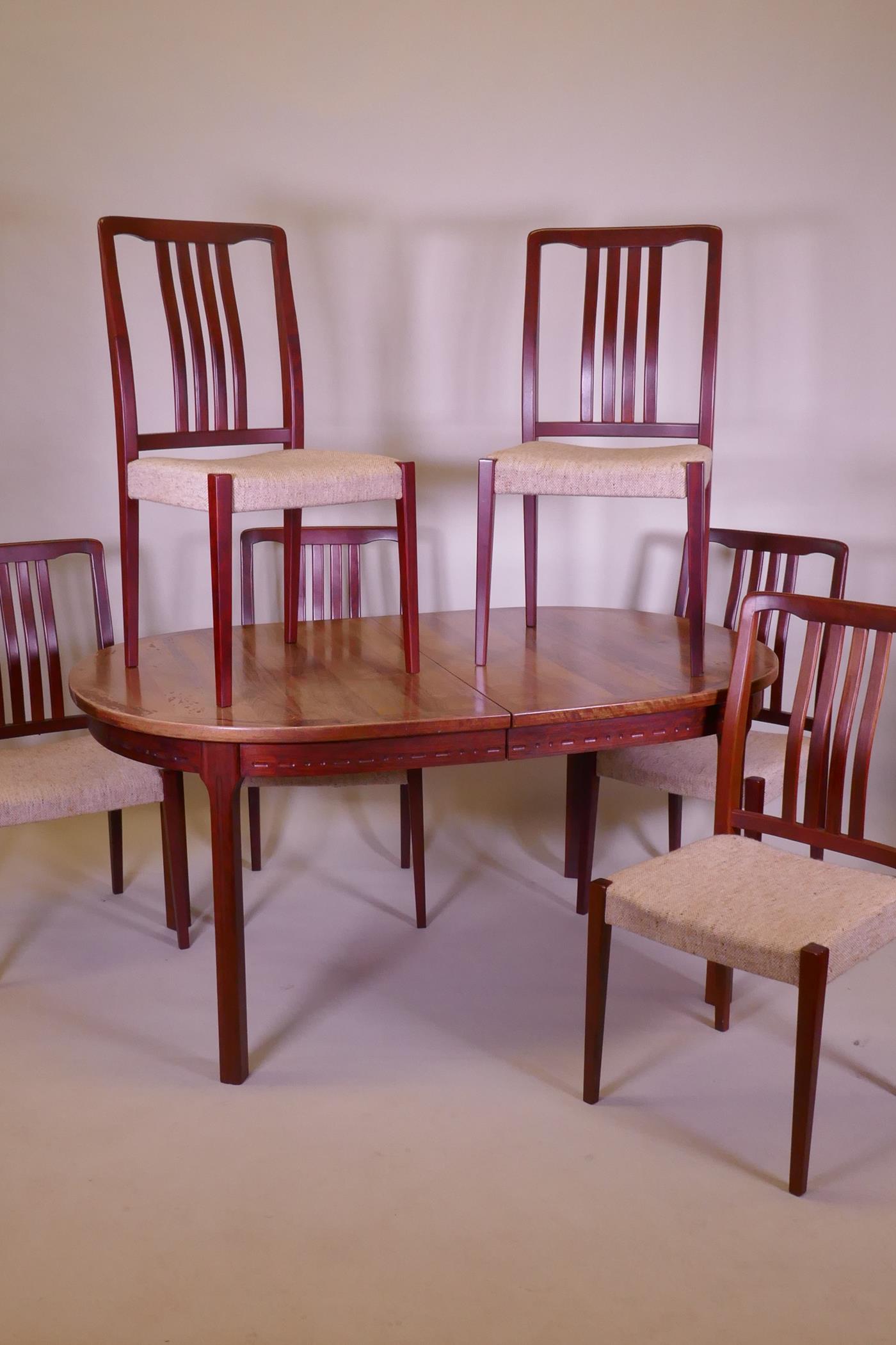 A mid century Danish Bjarnum dining table and seven chairs by Troeds, the table with two stowed