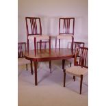 A mid century Danish Bjarnum dining table and seven chairs by Troeds, the table with two stowed