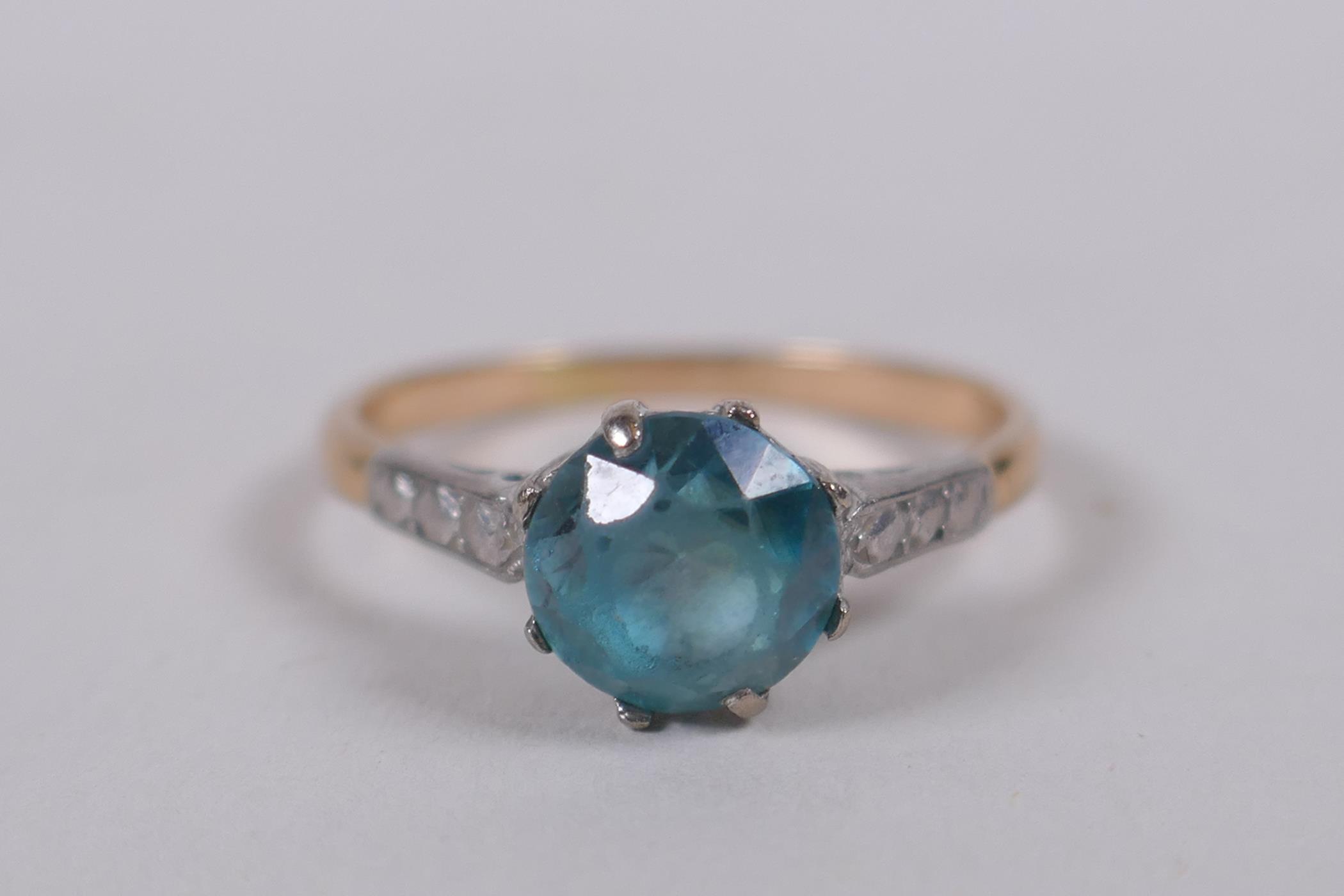 A yellow and white (unmarked) gold ring set with a blue/green stone (tests as spinel), size M/N
