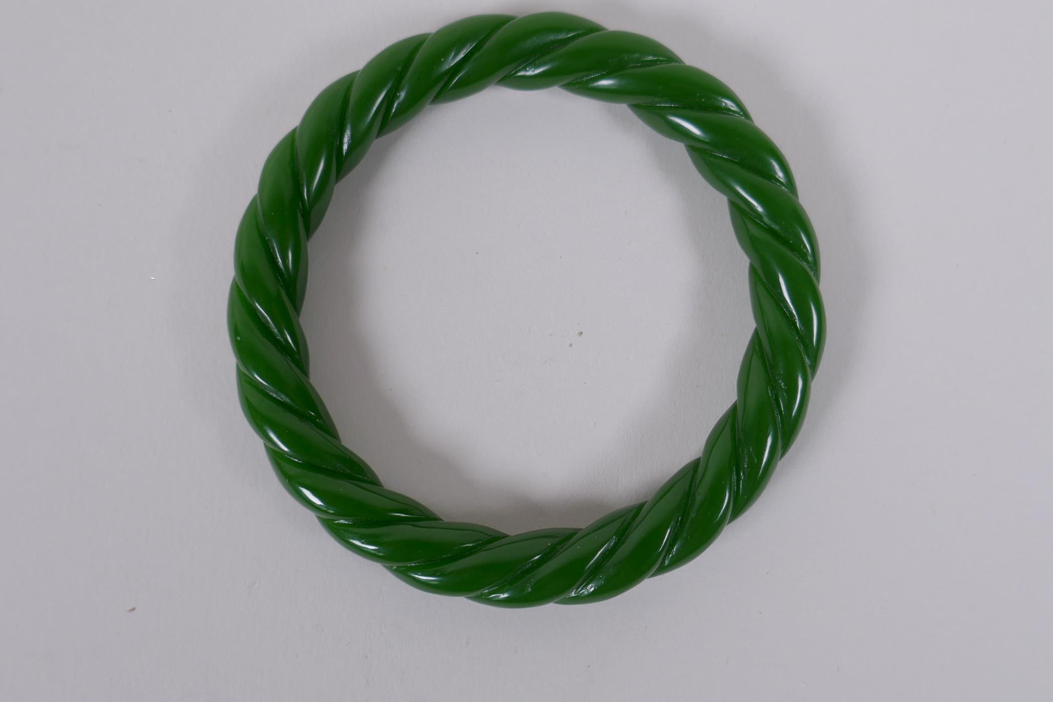 A Chinese carved green hardstone 'twist' bangle, 8cm diameter - Image 2 of 2