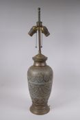 An Islamic brass vase with chased script decoration, converted to a table lamp, 67cm high