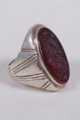 An Islamic white metal ring set with an agate intaglio seal carved with Islamic script, size W/X