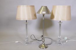 A pair of lucite/acrylic table lamps, 68cm high with shade, and a brushed metal lamp and shade