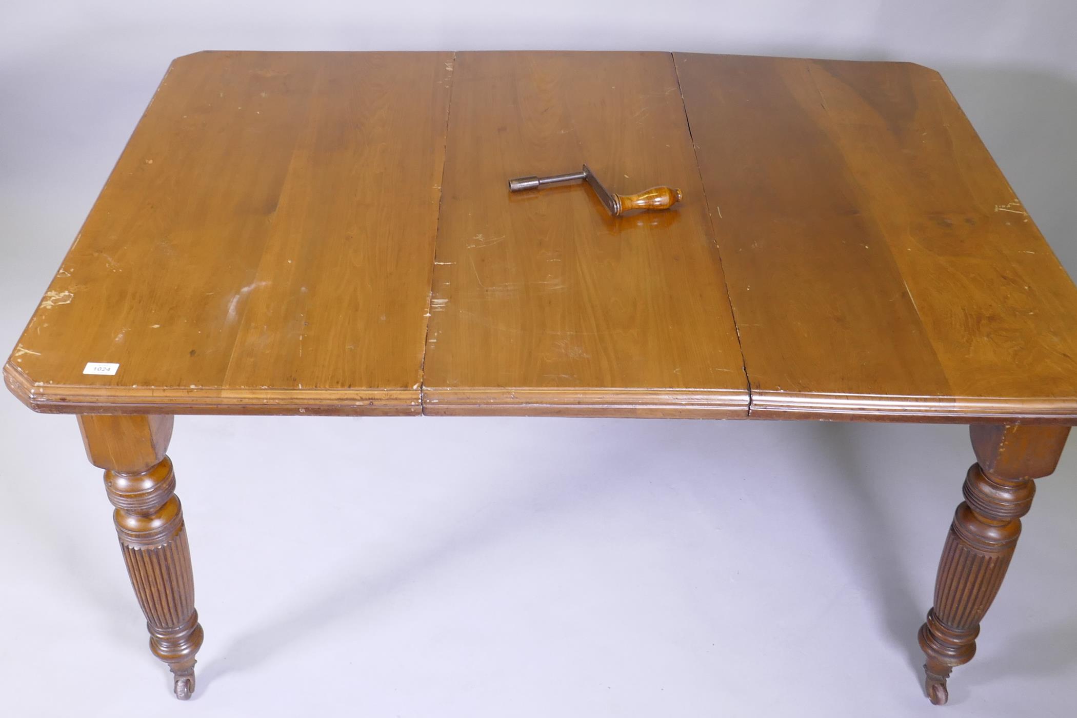 A Victorian mahogany wind out dining table and leaf, on turned and fluted supports, extended 144 x - Image 2 of 3