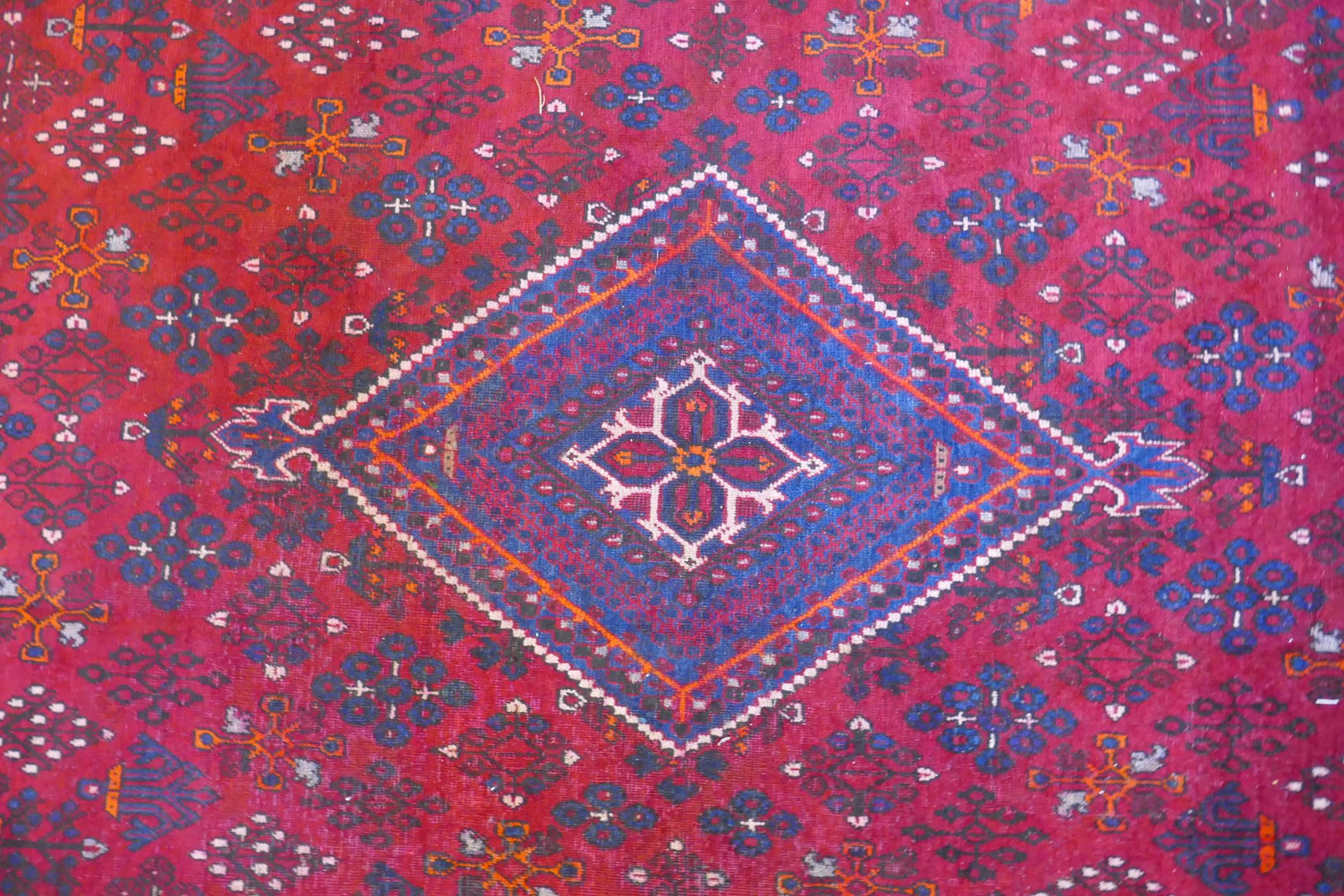 A claret and blue ground Persian Joshaghan tribal carpet with traditional medallion design, - Image 3 of 7