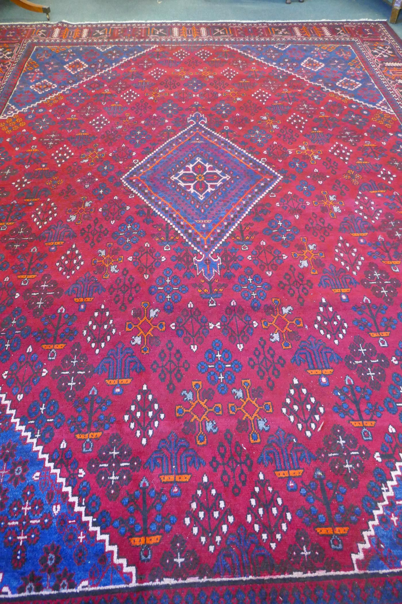 A claret and blue ground Persian Joshaghan tribal carpet with traditional medallion design, - Image 4 of 7