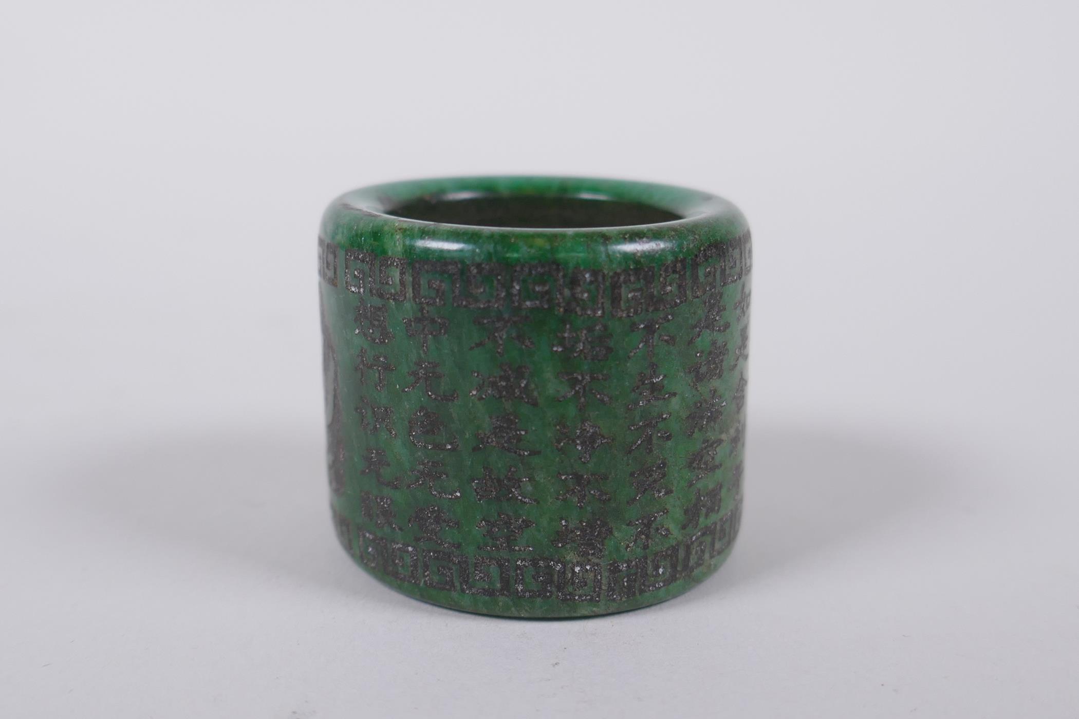 A Chinese marbled green hardstone archers thumb ring, decorated with an allover character