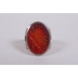 An Islamic white metal ring set with an agate intaglio seal, carved with Islamic script, marks to