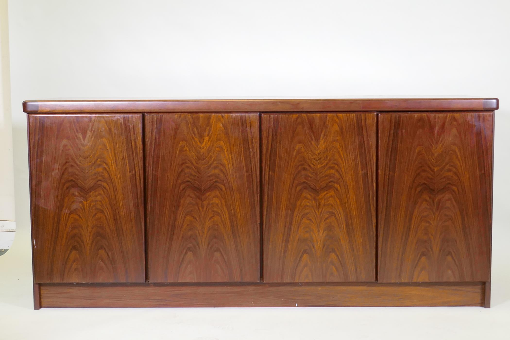 A Danish two section display cabinet, the upper section with four glazed doors, filled with glass