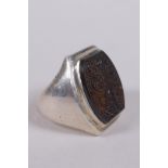 An Islamic white metal ring set with an intaglio seal carved with Islamic script, marks to interior,