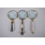 Three brass magnifying glasses with mother of pearl glass and metal handles, 25cm