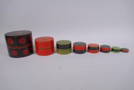 A set of oriental lacquered wood cylinder nesting boxes, largest 12cm diameter