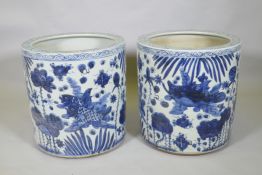 A pair of Chinese blue and white porcelain cylinder jardinieres decorated with carp in a lotus pond,