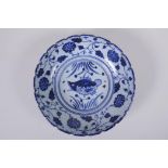 An early C20th Chinese blue and white porcelain bowl with shaped rim, decorated with a carp and