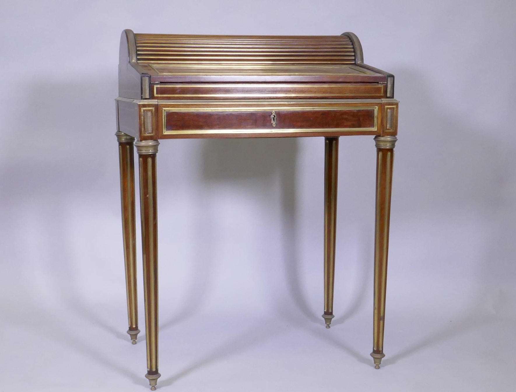 A French mahogany bonne heure du jour, with brass mounts, the pull out drawer operating the