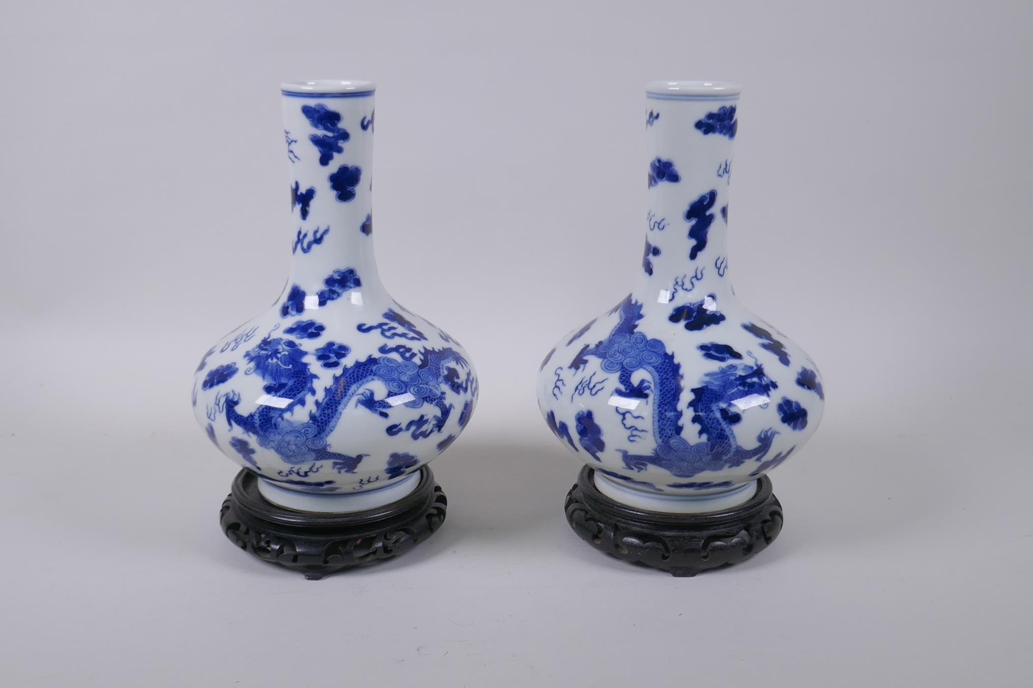 A pair of blue and white porcelain vases with dragon decoration, on carved hardwood stands, - Image 2 of 3