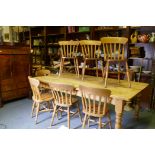 A pine farmhouse table, raised on turned supports, 213 x 120cm, and seven lathe back Windsor chairs