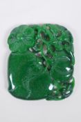 A Chinese carved and pierced green hardstone pendant decorated with fruit, bats and flowers, 7 x 8cm