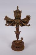 A Tibetan bronze decorative phurba in the form of a many armed and winged wrathful deity, 28cm high