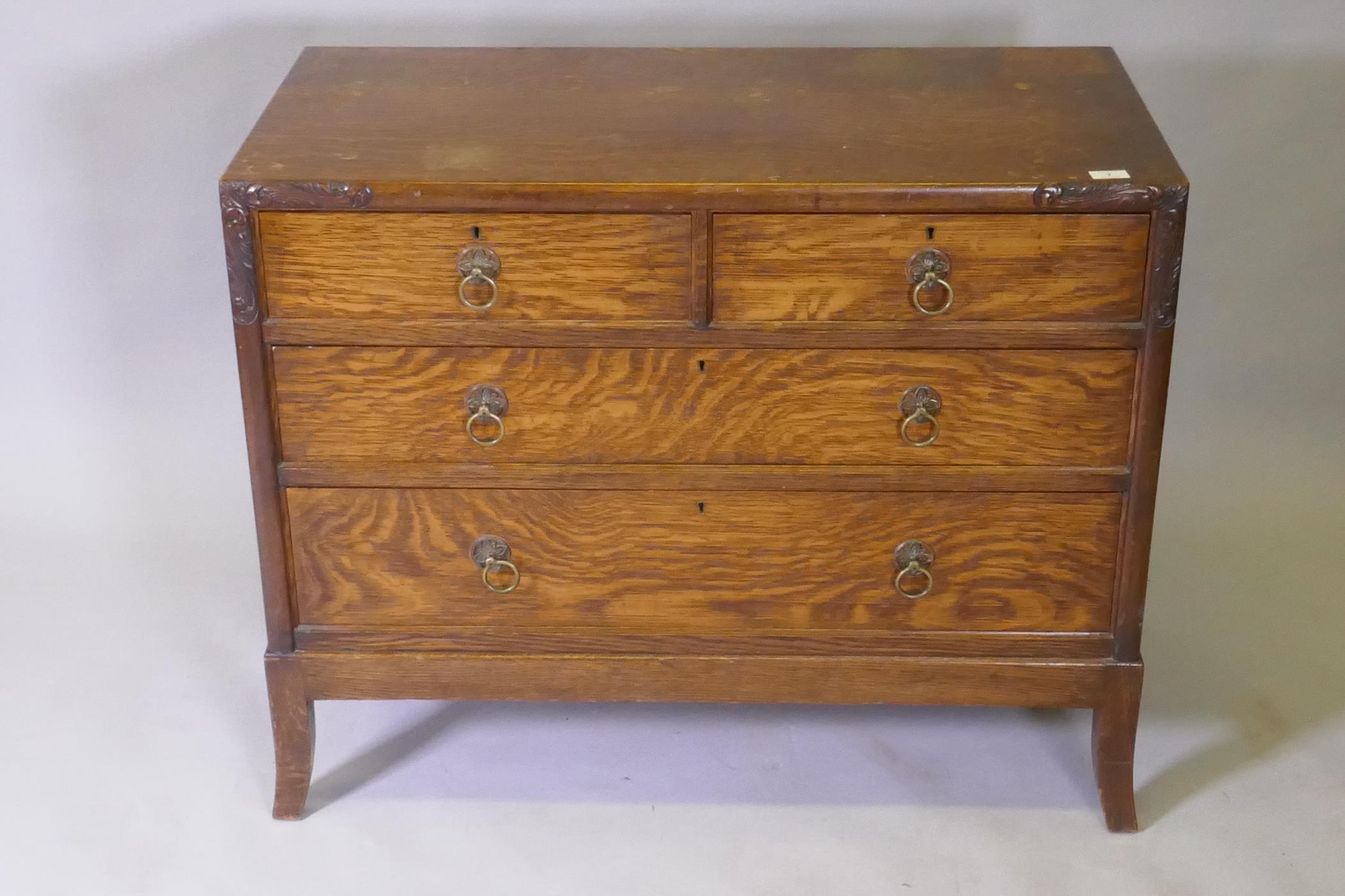 An Arts & Crafts oak chest of two over two drawers, with carved decoration and brass handles, raised - Image 2 of 5