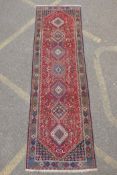 A south Persian Ghashgai red ground wool runner, decorated with a string of medallions, birds and