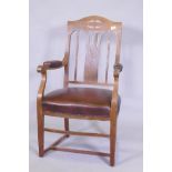 An Arts & Crafts oak armchair with pierced splat back, studded leather seat and arm rests, and