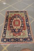 A Kazak Caucasian multicolour ground wool rug with a central medallion design and blue borders,