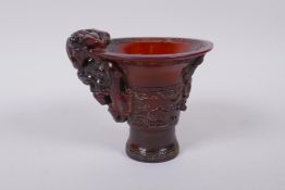 A Chinese horn libation cup with climbing kylin decoration, character mark to base, 12cm high