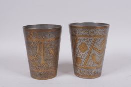 A pair of Islamic chased and gilt white metal beakers with script and floral decoration, 12cm high