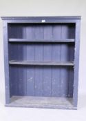 A painted open book-case with two sheves, raised on a plinth base, 102 x 34 x 123 cm