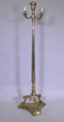 A brass floor lamp with three branches and fluted column, raised on three paw supports, 142cm high